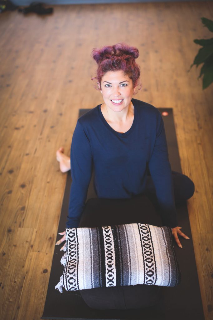 Erin Holmes from Peace Love And Yoga, shares a peaceful Restorative Yoga Flow; woman in a restorative yoga pose. 
